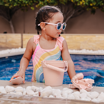 Little Sol+ Children's Beach and Pool Accessories - UV-protected sunglasses, colorful towels, buckets, and comfortable sandals for sustainable fun.
