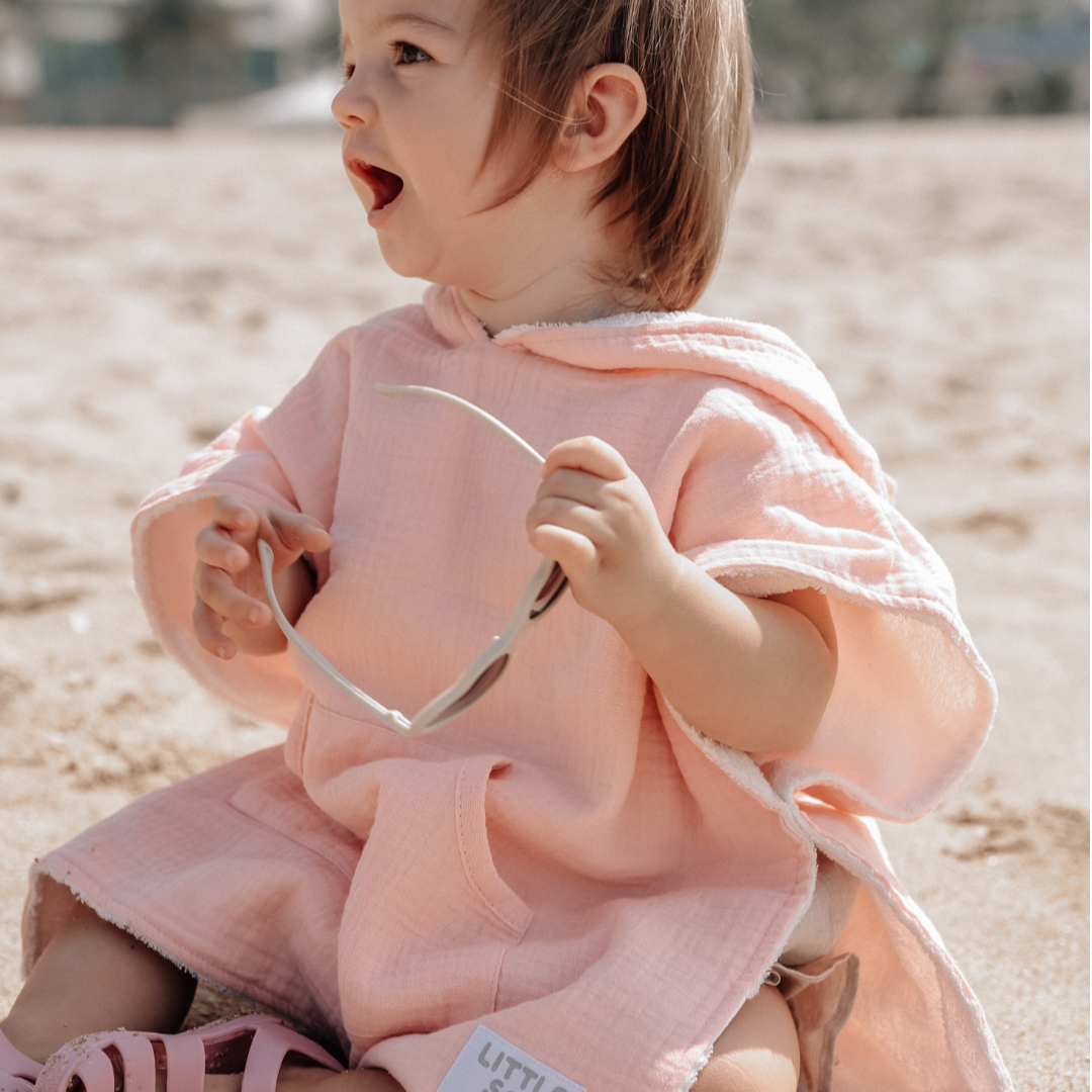 Baby wearing Little Sol+ beach towel.